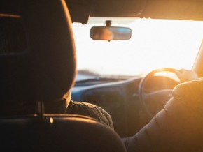 2 people driving their car in the sun