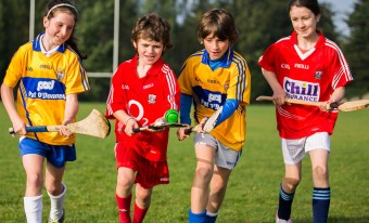 4 children playing GAA with a sliotar that says Better Energy