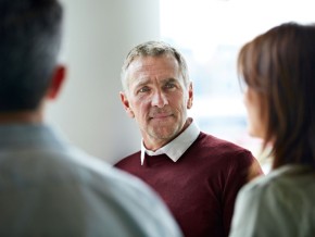 3 people engaged in a discussion in a meeting