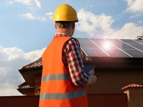 Contractor in a hard hat installing solar panels