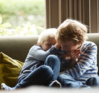 2 children playing on a couch in their home