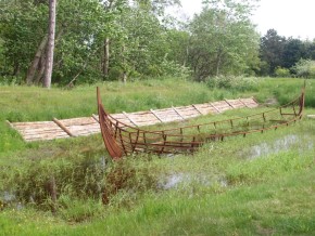 A wooden boat structure in a field