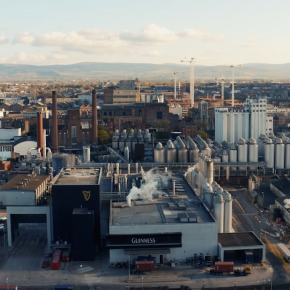 An aerial photograph of the Diageo factory with the city and mountains in the background.