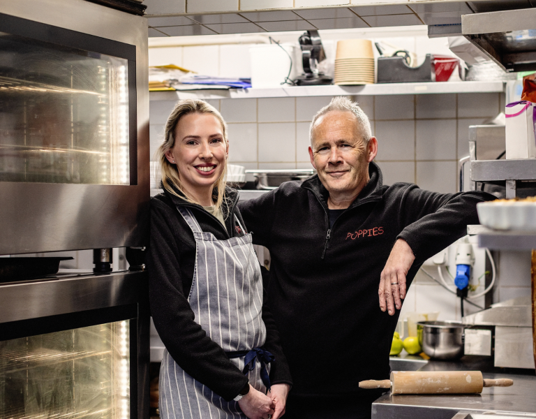 The owners of Poppies standing in their kitchen