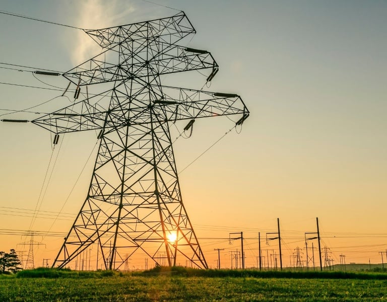 Power transmissions tower against sunset