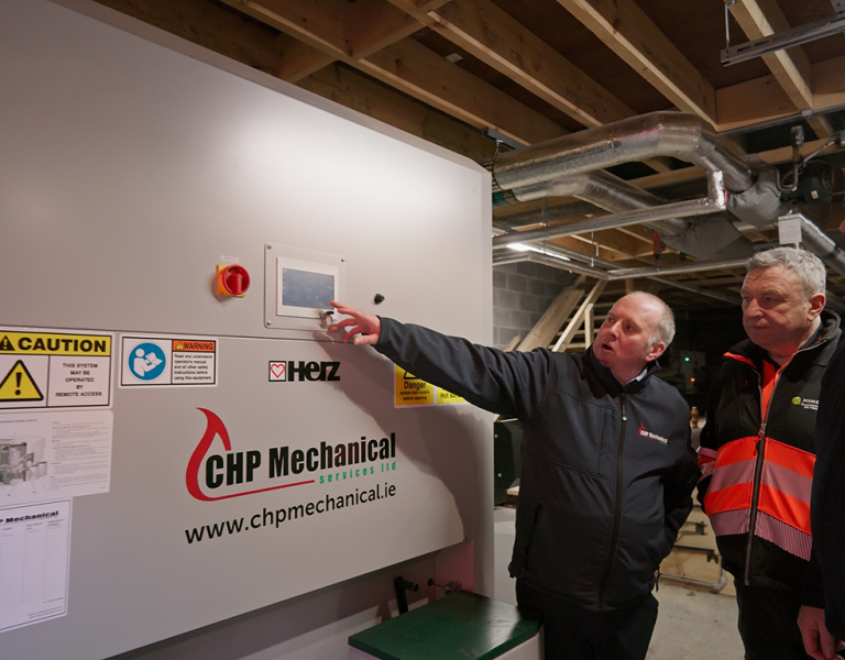 Three men looking at The biomass boiler at Markree Castle Hotel.