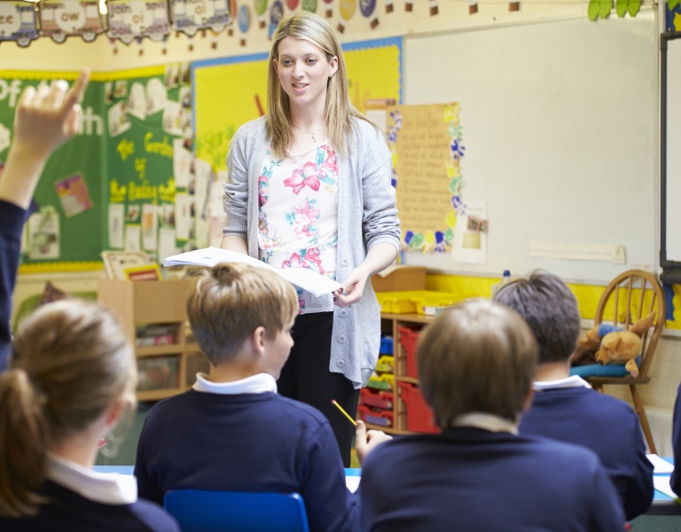 A teacher teaching a classroom full of children