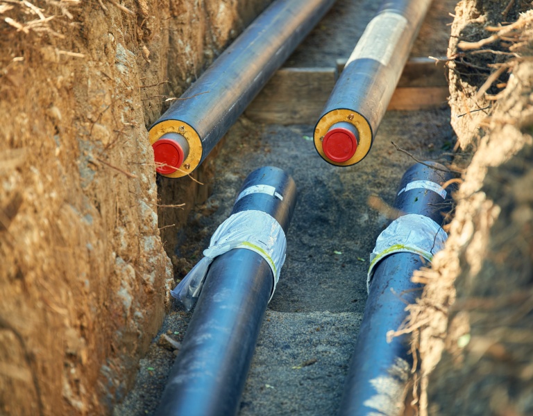 Underground insulated district heating and cooling pipes