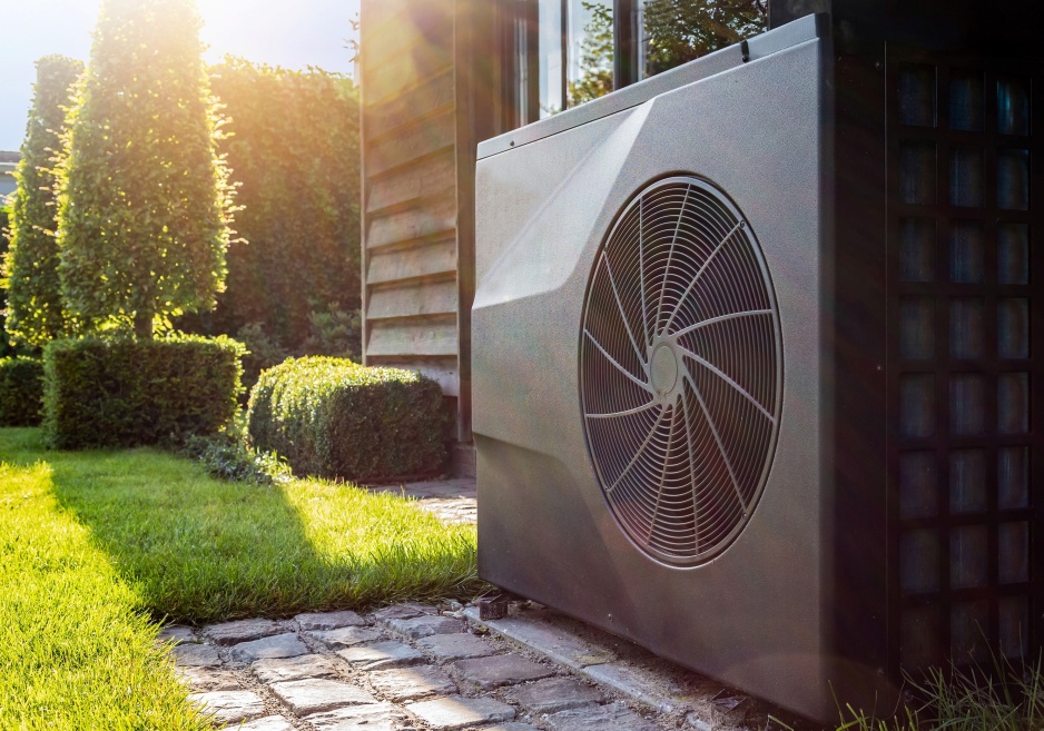 A grey heat pump in a homeowner's garden