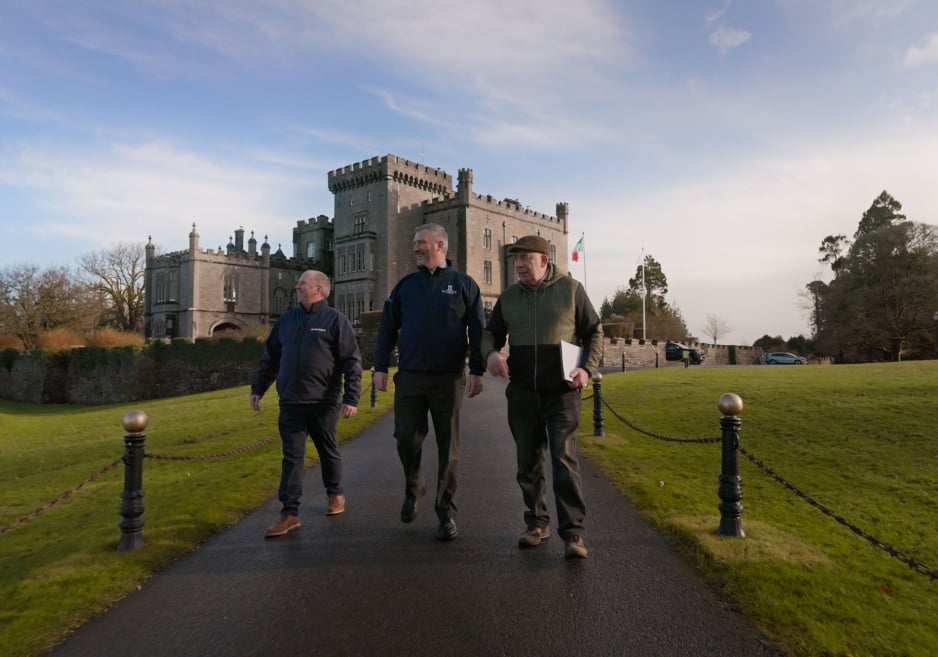 Three men walking with Markree Castle Hotel in the background.