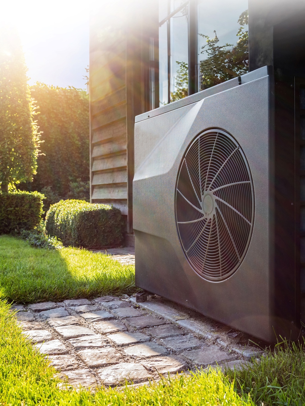 A grey heat pump in a homeowner's garden
