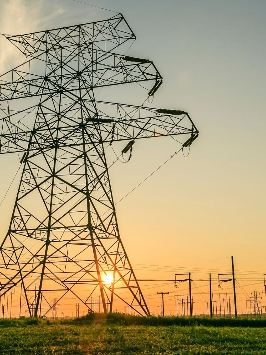 Power transmissions tower against sunset