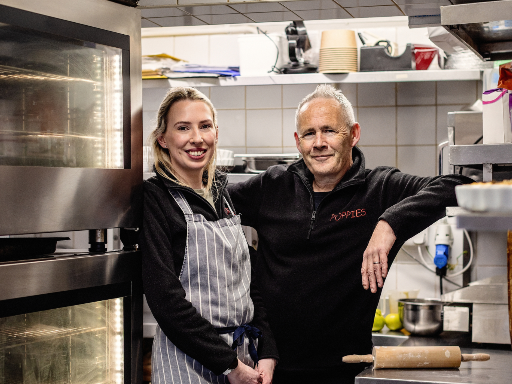 The owners of Poppies standing in their kitchen