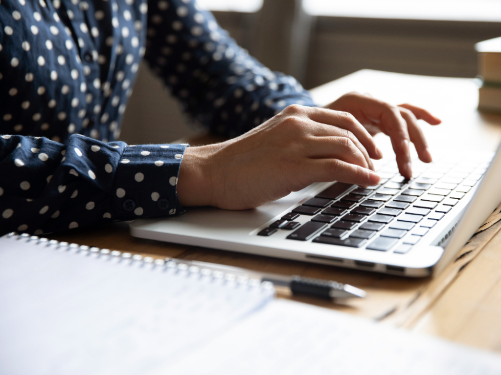 a woman typing on a laptop